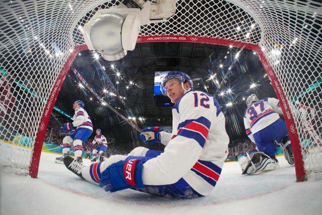 USA's #12 Matt Boldy falls into the goal during the men's preliminary round Group C Ice Hockey match between Latvia and USA at the Milano Santagiulia Ice Hockey Arena during the Milano Cortina 2026 Winter Olympic Games in Milan, on February 12, 2026. (Photo by POOL / AFP)