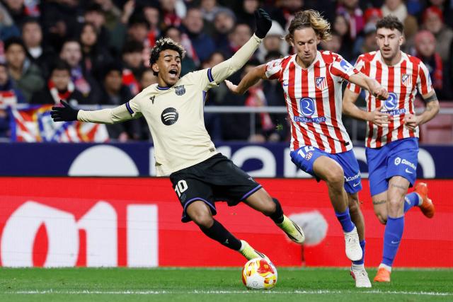 Barcelona's Spanish forward #10 Lamine Yamal and Atletico Madrid's Spanish midfielder #14 Marcos Llorente fight for the ball during the Spanish Copa del Rey (King's Cup) semi final first leg football match between Club Atletico de Madrid and FC Barcelona at Metropolitano Stadium in Madrid on February 12, 2026. (Photo by Oscar DEL POZO / AFP)