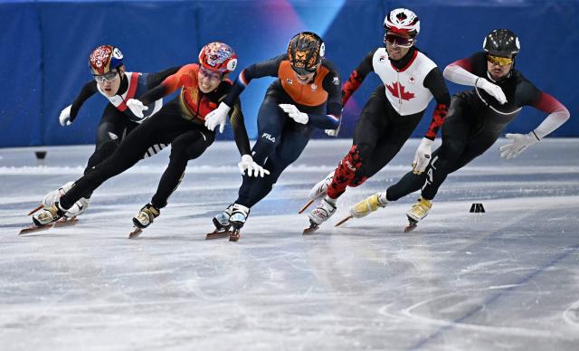 South Korea's Rim Jong-un, China's Sun Long, Netherlands' Jens van 't Wout, Canada's William Dandjinou and Latvia's Roberts Kruzbergs approach the finish line as they compete in the short track speed skating men's 1000m final during the Milano Cortina 2026 Winter Olympic Games at Milano Ice Skating Arena in Milan on February 12, 2026. (Photo by Gabriel BOUYS / AFP)