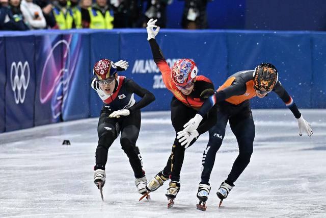 South Korea's Rim Jong-un, China's Sun Long and Netherlands' Jens van 't Wout cross the finish line as they compete in the short track speed skating men's 1000m final during the Milano Cortina 2026 Winter Olympic Games at Milano Ice Skating Arena in Milan on February 12, 2026. (Photo by Gabriel BOUYS / AFP)