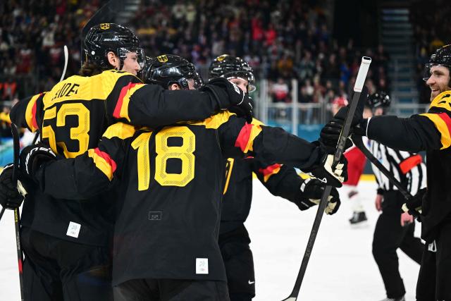 Germany's #18 Tim Stutzle (C) celebrates with teammates after scoring a goal during the men's preliminary round Group C Ice Hockey match between Germany and Denmark at the Milano Rho Ice Hockey Arena at the Milano Cortina 2026 Winter Olympic Games in Milan, on February 12, 2026. (Photo by Piero CRUCIATTI / AFP)