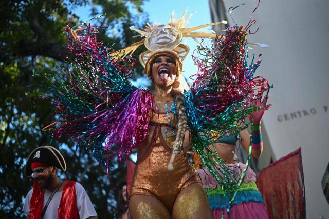 Revellers attend the parade of the Loucura Suburbana (Suburban Craziness) street carnival group at the Engenho de Dentro neighborhood in Rio de Janeiro, Brazil on February 12, 2026. (Photo by Mauro PIMENTEL / AFP)