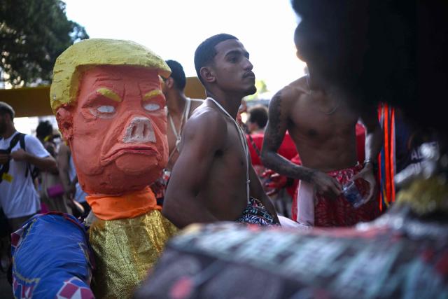 A giant puppet depicting US President Donald Trump is seen during the parade of the Loucura Suburbana (Suburban Craziness) street carnival group at the Engenho de Dentro neighborhood in Rio de Janeiro, Brazil on February 12, 2026. (Photo by Mauro PIMENTEL / AFP)
