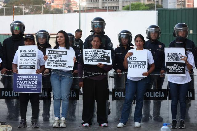 Relatives of political prisoners hold signs as they take part in a protest outside the Bolivarian National Police (PNB) Zone 7 prison in Caracas on February 12, 2026. Venezuela's legislature on February 12 postponed the adoption of a landmark amnesty bill expected to lead to the release of hundreds of political prisoners. (Photo by Pedro MATTEY / AFP)