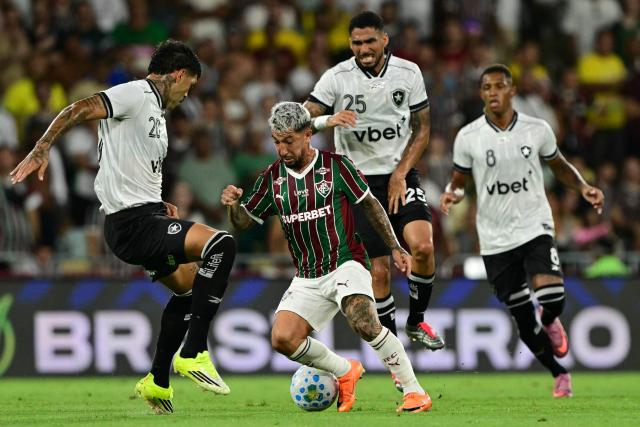 Botafogo's Argentine defender #20 Alexander Barboza and Fluminense's Argentine midfielder #32 Luciano Acosta fight for the ball during the Campeonato Brasileiro Serie A football match between Fluminense and Botafogo at the Maracana Stadium in Rio de Janeiro, Brazil, on February 12, 2026. (Photo by Pablo PORCIUNCULA / AFP)