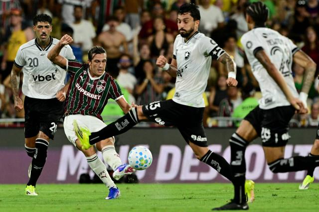 Fluminense's Uruguayan midfielder #17 Agustin Canobbio and Botafogo's defender #13 Alex Telles fight for the ball during the Campeonato Brasileiro Serie A football match between Fluminense and Botafogo at the Maracana Stadium in Rio de Janeiro, Brazil, on February 12, 2026. (Photo by Pablo PORCIUNCULA / AFP)