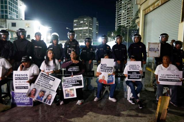 Relatives of political prisoners hold signs as they take part in a protest outside the Bolivarian National Police (PNB) Zone 7 prison in Caracas on February 12, 2026. Venezuela's legislature on February 12 postponed the adoption of a landmark amnesty bill expected to lead to the release of hundreds of political prisoners. (Photo by Pedro MATTEY / AFP)