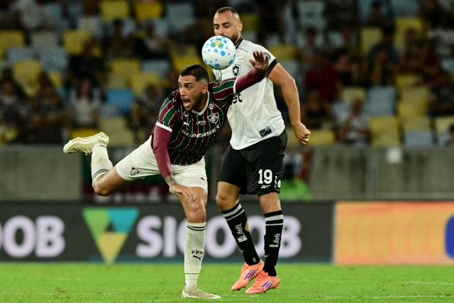 Fluminense's Argentine defender #22 Juan Pablo Freytes and Botafogo's forward #19 Arthur Cabral fight for the ball during the Campeonato Brasileiro Serie A football match between Fluminense and Botafogo at the Maracana Stadium in Rio de Janeiro, Brazil, on February 12, 2026. (Photo by Pablo PORCIUNCULA / AFP)