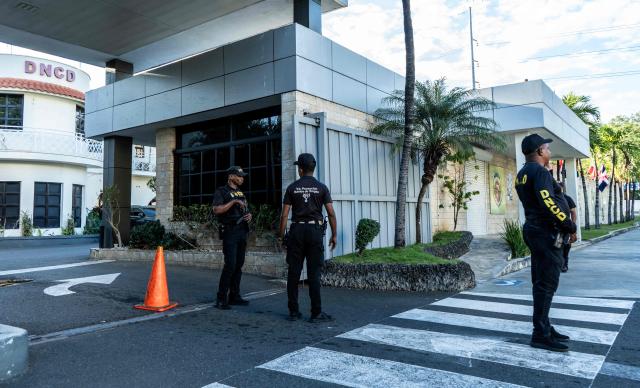 Dominican police officers stand at the entrance to the headquarters of the National Drug Control Directorate in Santo Domingo on February 12, 2026. The United States said on February 12, 2026, it was closing its Drug Enforcement Administration office in the Dominican Republic over unspecified corruption claims. (Photo by Danny Polaco / AFP)