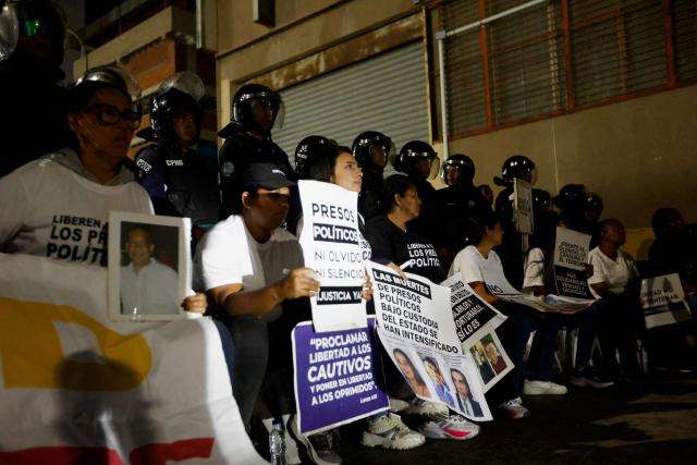 Relatives of political prisoners hold signs as they take part in a protest outside the Bolivarian National Police (PNB) Zone 7 prison in Caracas on February 12, 2026. Venezuela's legislature on February 12 postponed the adoption of a landmark amnesty bill expected to lead to the release of hundreds of political prisoners. (Photo by Pedro MATTEY / AFP)