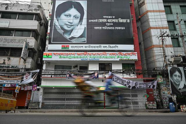 A rickshaw puller rides past the Bangladesh Nationalist Party (BNP) office as counting continues in Bangladesh's general election, in Dhaka on February 13, 2026. The Bangladesh Nationalist Party (BNP) led by Tarique Rahman is heading for a thumping win in the first elections held since a deadly 2024 uprising, Bangladeshi TV stations projected on February 13. (Photo by Sajjad HUSSAIN / AFP)