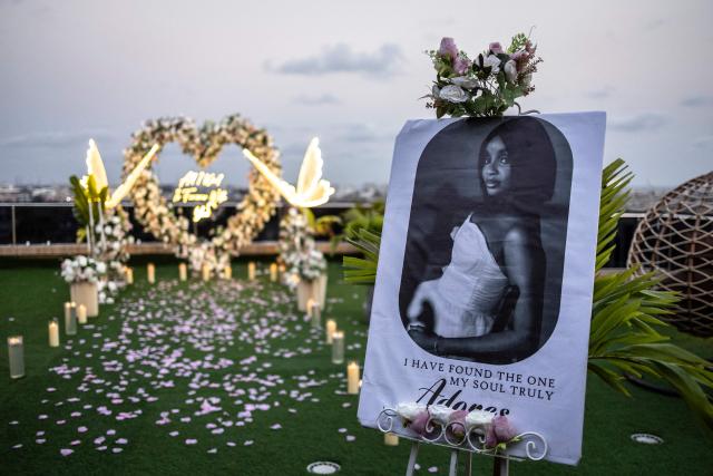 A portrait of a bride-to-be stands amid a floral arrangement set up for a surprise engagement on the rooftop of a private residence in Lagos on February 7, 2026. (Photo by OLYMPIA DE MAISMONT / AFP)
