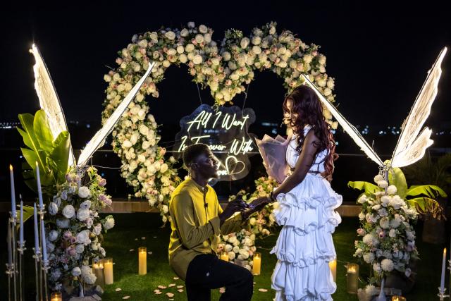 James Obiri, a groom-to-be, kneels to propose to Fehintola Da-Silva, his girlfriend, during a surprise engagement on the rooftop of a private residence in Lagos, on February 7, 2026. (Photo by OLYMPIA DE MAISMONT / AFP)