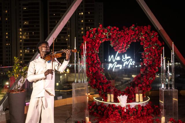 (FILES) A violinist perform ahead of a surprise engagement on the rooftop of the Turaka restaurant in Lagos, Nigeria, on September 6, 2025. The five-months old matchmaking site, which is one of several online matchmaking platforms that have sprung up in the city, has attracted 1,000 clients and garnered around 10,000 following across social media platforms, according to Jaafar Isah Shanawa, its 27-year old CEO.  With four staff, the matchmaking platform accords privacy to its clients by modifying their pictures using AI-generated tools and changing their real names and addresses.
The concealed details are only shown to  interested clients when they visit the office in person after paying the required registration fees. (Photo by OLYMPIA DE MAISMONT / AFP)