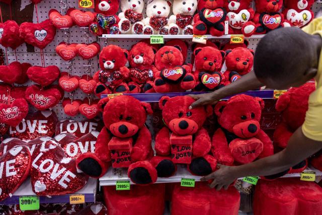 A shop attendant arranges gifts at the House of Leather gift shop ahead of Valentine's Day in Nairobi, on February 11, 2026. (Photo by SIMON MAINA / AFP)