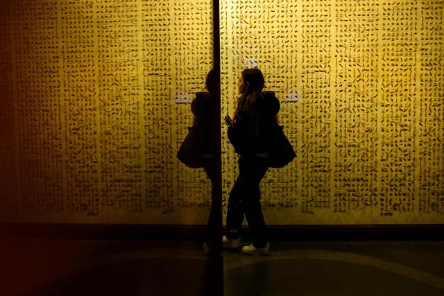 A visitor walks in front of a wall in The Museum of Innocence in Istanbul on February 10, 2026. On a cobbled street in Cukurcuma, a district known for its antiques shops on Istanbul's European side, the story penned by Nobel Literature Prize-winning Turkish author Orhan Pamuk has been brought to life inside the walls of a red-painted house. (Photo by Yasin AKGUL / AFP)