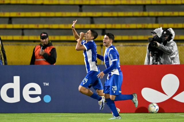 Juventud's defender #24 Federico Barrandeguy (L) celebrates scoring his team's second goal during the Copa Libertadores phase one second-leg football match between Ecuador's Universidad Catolica and Uruguay's Juventud at the Olimpico Atahualpa stadium in Quito on February 12, 2026. (Photo by Rodrigo BUENDIA / AFP)