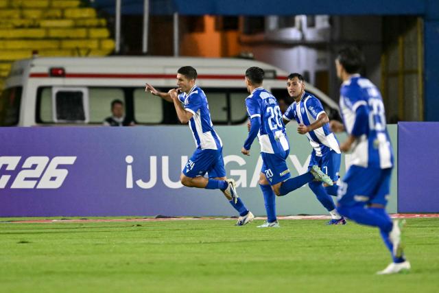 Juventud's defender #24 Federico Barrandeguy (L) celebrates scoring his team's second goal during the Copa Libertadores phase one second-leg football match between Ecuador's Universidad Catolica and Uruguay's Juventud at the Olimpico Atahualpa stadium in Quito on February 12, 2026. (Photo by Rodrigo BUENDIA / AFP)