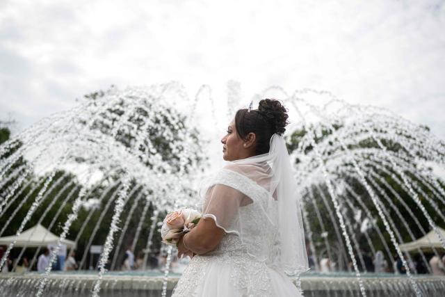 A bride poses for a photo during a mass wedding at the Magic Water Park in Lima on February 12, 2026. (Photo by Ernesto BENAVIDES / AFP)