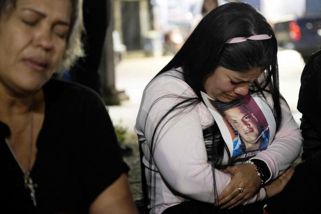 A woman mourns as she embraces a portrait of a relative during a vigil of relatives of political prisoners outside El Rodeo I prison in Guatire, Miranda state, Venezuela, on February 12, 2026. Venezuela's legislature on February 12 postponed the adoption of a landmark amnesty bill expected to lead to the release of hundreds of political prisoners. (Photo by Maryorin Mendez / AFP)