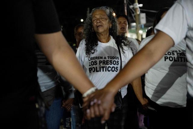 TOPSHOT - A woman mourns during a vigil of relatives of political prisoners outside El Rodeo I prison in Guatire, Miranda state, Venezuela, on February 12, 2026. Venezuela's legislature on February 12 postponed the adoption of a landmark amnesty bill expected to lead to the release of hundreds of political prisoners. (Photo by Maryorin Mendez / AFP)