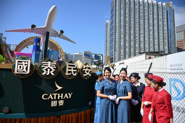 Performers on the Cathay Pacific float prepare to dance at a media preview for the upcoming Lunar New Year parade in Hong Kong on February 13, 2026, ahead of the Lunar New Year of the Horse. (Photo by Peter PARKS / AFP)