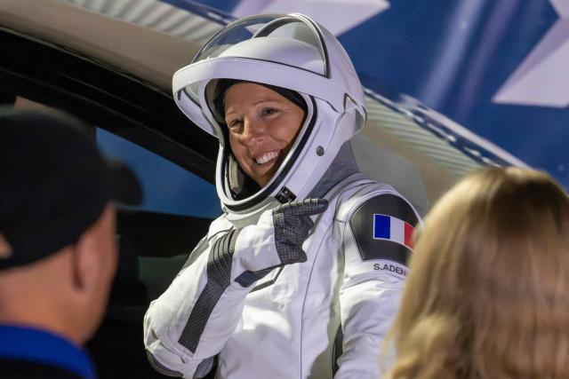 ESA (European Space Agency) astronaut Sophie Adenot points to the French flag on her shoulder as she prepares to travel to the SpaceX Falcon 9 rocket with the company's Dragon spacecraft at Space Launch Complex 40 for the Crew-12 mission at Cape Canaveral Space Force Station in Florida, on February 13, 2026. (Photo by Jim WATSON / AFP)