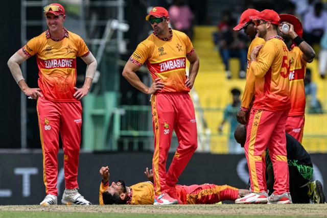 Zimbabwe's captain Sikandar Raza (bottom) reacts after an injury as his teammates watch during the 2026 ICC Men's T20 Cricket World Cup group stage match between Australia and Zimbabwe at the R Premadasa Stadium in Colombo on February 13, 2026. (Photo by Ishara S. KODIKARA / AFP)