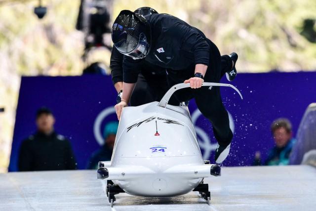 South Korea's Kim Jinsu pilots in the bobsleigh men's 2-man training Heat 3 at Cortina Sliding Centre during the Milano Cortina 2026 Winter Olympic Games in Cortina d'Ampezzo on February 13, 2026. (Photo by Stefano RELLANDINI / AFP)