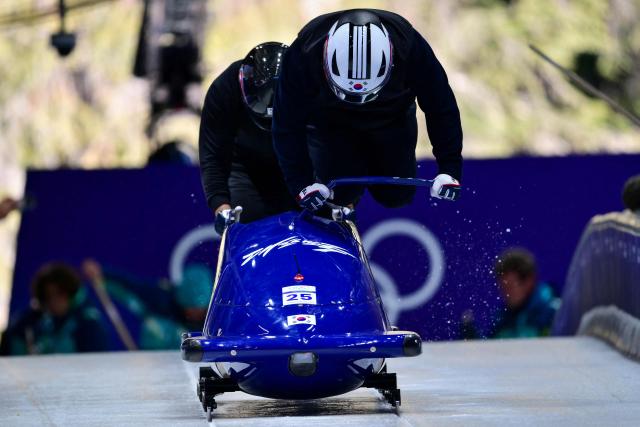 South Korea's Suk Youngjin pilots in the bobsleigh men's 2-man training Heat 3 at Cortina Sliding Centre during the Milano Cortina 2026 Winter Olympic Games in Cortina d'Ampezzo on February 13, 2026. (Photo by Stefano RELLANDINI / AFP)