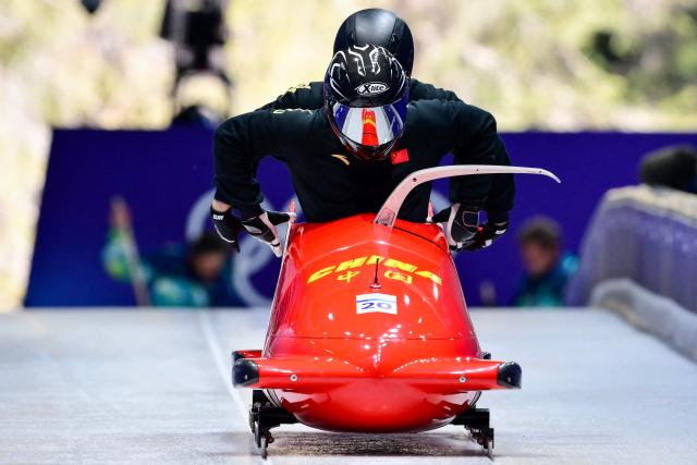 China's Sun Kaizhi pilots in the bobsleigh men's 2-man training Heat 3 at Cortina Sliding Centre during the Milano Cortina 2026 Winter Olympic Games in Cortina d'Ampezzo on February 13, 2026. (Photo by Stefano RELLANDINI / AFP)