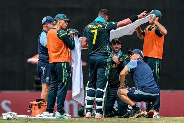 Australia's Glenn Maxwell (C) takes shelter under a towel from the sun during the 2026 ICC Men's T20 Cricket World Cup group stage match between Australia and Zimbabwe at the R Premadasa Stadium in Colombo on February 13, 2026. (Photo by Ishara S. KODIKARA / AFP)