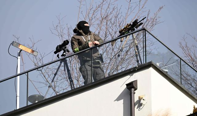 A sniper of the police stands on a roof close to the Hotel Bayerischer Hof, venue of the Munich Security Conference (MSC) in Munich, southern Germany on February 13, 2026. Heads of state and government as well as foreign and defence ministers from all over the world are expected to attend the security policy talks from February 13 to 15, 2026. (Photo by THOMAS KIENZLE / AFP)