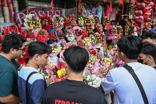 People buy flowers at a market ahead of Valentine's Day in Manila on February 13, 2026. (Photo by Jam STA ROSA / AFP)