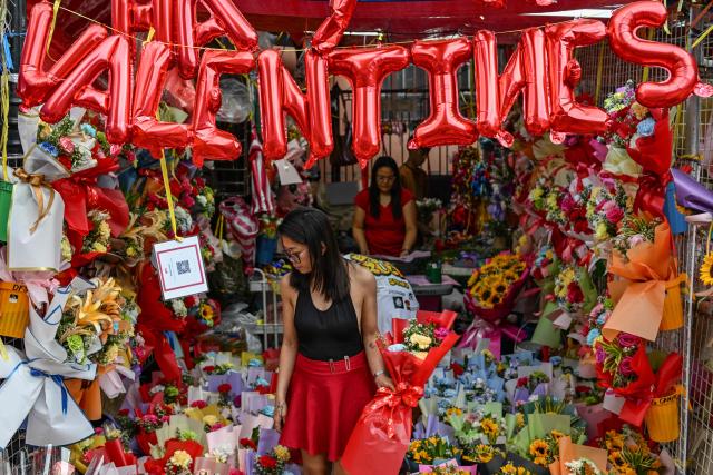 People buy flowers at a market ahead of Valentine's Day in Manila on February 13, 2026. (Photo by Jam STA ROSA / AFP)