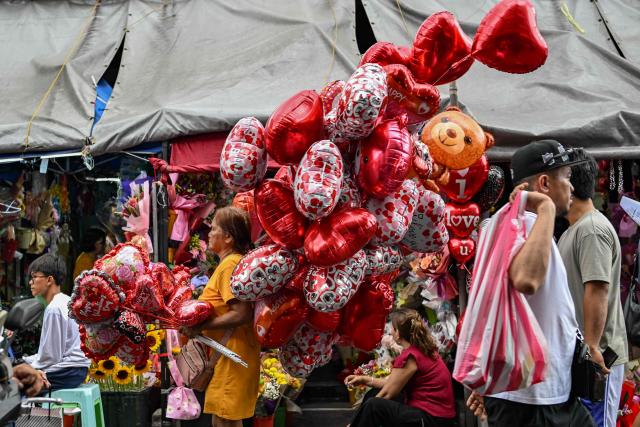 A woman sells heart-shaped balloons at a market ahead of Valentine's Day in Manila on February 13, 2026. (Photo by Jam STA ROSA / AFP)