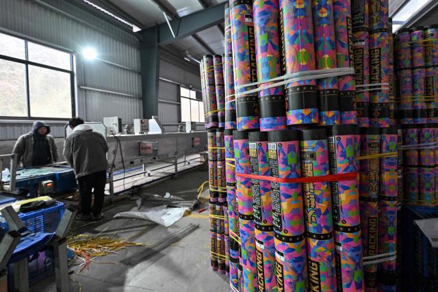 In this photo taken on January 21, 2026, qorkers work at a fireworks factory in Liuyang town, Changsha, central China's Hunan province. A fiery crack of red and gold explodes above a village in southern China's Liuyang, where residents are accustomed to ear-splitting fireworks tests year-round in the country's pyrotechnics production hub. (Photo by Adek BERRY / AFP) / To go with 'CHINA-ECONOMY-FIREWORKS'