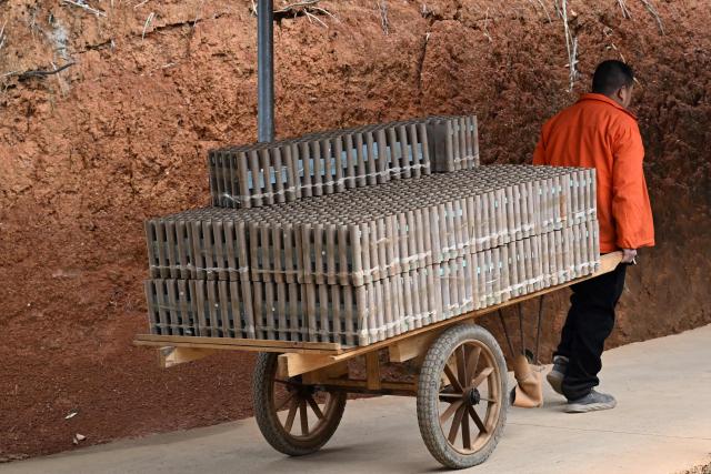 In this photo taken on January 22, 2026, a man works at a fireworks factory in Liuyang town, Changsha, central China's Hunan province. A fiery crack of red and gold explodes above a village in southern China's Liuyang, where residents are accustomed to ear-splitting fireworks tests year-round in the country's pyrotechnics production hub. (Photo by Adek BERRY / AFP) / To go with 'CHINA-ECONOMY-FIREWORKS'