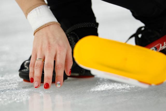 A nail with the Olympic rings logo is seen on the right hand of Denmark's Jasmin Holtermann  during the curling women's round robin between Denmark and Japan during the Milano Cortina 2026 Winter Olympic Games at the Cortina Curling Olympic Stadium in Cortina d’Ampezzo on February 12, 2026. (Photo by Odd ANDERSEN / AFP)
