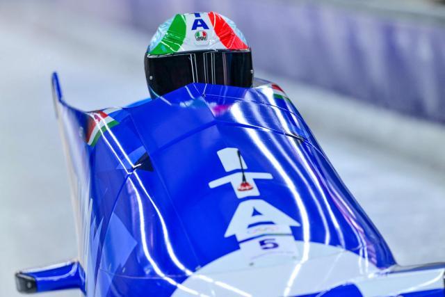 Italy's Patrick Baumgartner pilots in the bobsleigh men's 2-man training Heat 3 at Cortina Sliding Centre during the Milano Cortina 2026 Winter Olympic Games in Cortina d'Ampezzo on February 13, 2026. (Photo by Stefano RELLANDINI / AFP)