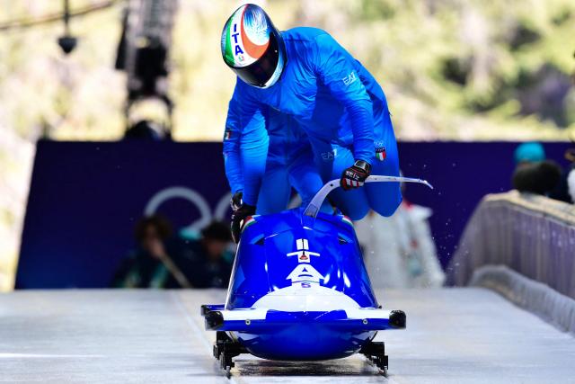 Italy's Patrick Baumgartner pilots in the bobsleigh men's 2-man training Heat 3 at Cortina Sliding Centre during the Milano Cortina 2026 Winter Olympic Games in Cortina d'Ampezzo on February 13, 2026. (Photo by Stefano RELLANDINI / AFP)