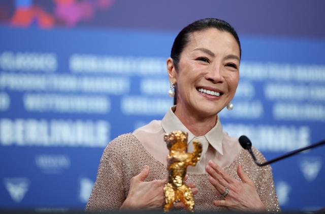 Malaysian actress Michelle Yeoh sits behind the Honorary Golden Bear trophy she was awarded "in recognition of her outstanding achievements in film and cinema" at a press conference during the Berlinale, Europe's first major film festival of the year, in Berlin on February 13, 2026. (Photo by Ronny HARTMANN / AFP)