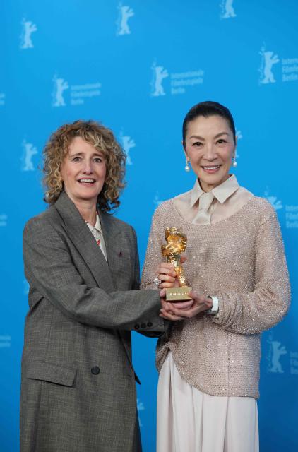 Malaysian actress Michelle Yeoh holds the Honorary Golden Bear trophy she was awarded "in recognition of her outstanding achievements in film and cinema" as she poses with Berlinale director Tricia Tuttle at a photocall during the Berlinale, Europe's first major film festival of the year, in Berlin on February 13, 2026. (Photo by Ronny HARTMANN / AFP)