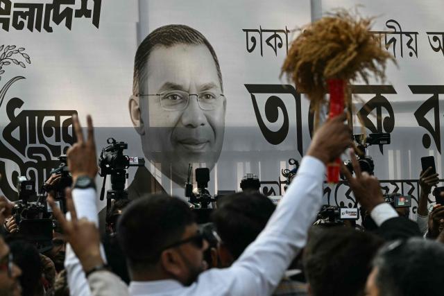 A poster of Bangladesh Nationalist Party (BNP) chairman and election candidate Tarique Rahman is displayed as supporters gather outside the party office in Dhaka on February 13, 2026. The Bangladesh Nationalist Party (BNP) celebrated a landslide victory on February 13 in the first elections held since a deadly 2024 uprising, with leader Tarique Rahman to become prime minister. (Photo by Sajjad HUSSAIN / AFP)