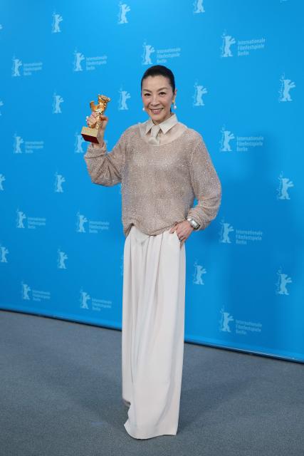 Malaysian actress Michelle Yeoh holds the Honorary Golden Bear trophy she was awarded "in recognition of her outstanding achievements in film and cinema" as she poses at a photocall during the Berlinale, Europe's first major film festival of the year, in Berlin on February 13, 2026. (Photo by Ronny HARTMANN / AFP)