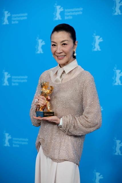 Malaysian actress Michelle Yeoh holds the Honorary Golden Bear trophy she was awarded "in recognition of her outstanding achievements in film and cinema" as she poses at a photocall during the Berlinale, Europe's first major film festival of the year, in Berlin on February 13, 2026. (Photo by Ronny HARTMANN / AFP)