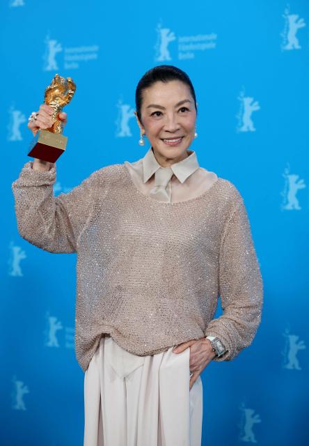 Malaysian actress Michelle Yeoh holds the Honorary Golden Bear trophy she was awarded "in recognition of her outstanding achievements in film and cinema" as she poses at a photocall during the Berlinale, Europe's first major film festival of the year, in Berlin on February 13, 2026. (Photo by Ronny HARTMANN / AFP)