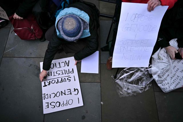 Protestors write on placards outside The Royal Courts of Justice, Britain's High Court, in London on February 13, 2026. Palestine Action co-founder Huda Ammori won a legal challenge Friday against a UK government ban on the activist group that has led to mass arrests and concerns over free speech and civil liberties. The government proscribed the group last July, days after activists protesting the war in Gaza broke into an air force base in southern England and caused millions of pounds worth of damage to two aircraft. (Photo by Ben STANSALL / AFP)