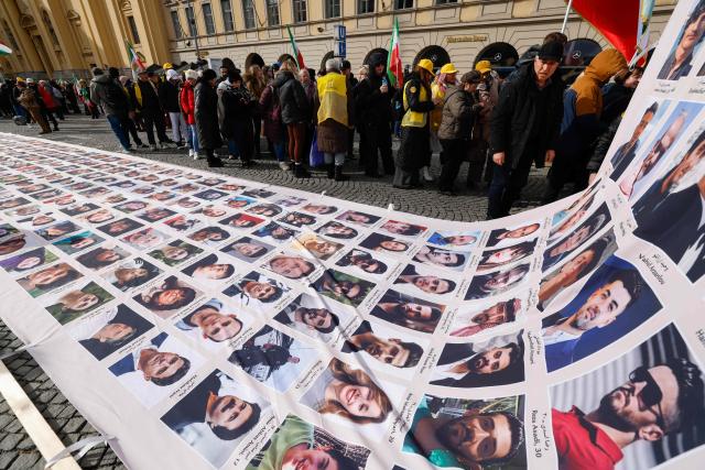 Protesters display a banner featuring portraits of alleged victims of the Iranian government during a demonstration against the Iranian government called by the People's Mujahedin of Iran (MEK), in Munich, southern Germany, on the sidelines of the 62nd Munich Security Conference (MSC) on February 13, 2026. Heads of state and government as well as foreign and defence ministers from all over the world are expected to attend the security policy talks from February 13 to 15, 2026. (Photo by Michaela STACHE / AFP)