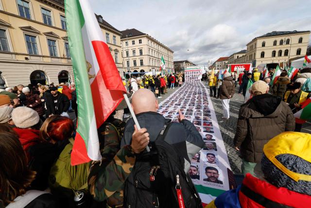 Protesters display a banner featuring portraits of alleged victims of the Iranian government during a demonstration against the Iranian government called by the People's Mujahedin of Iran (MEK), in Munich, southern Germany, on the sidelines of the 62nd Munich Security Conference (MSC) on February 13, 2026. Heads of state and government as well as foreign and defence ministers from all over the world are expected to attend the security policy talks from February 13 to 15, 2026. (Photo by Michaela STACHE / AFP)